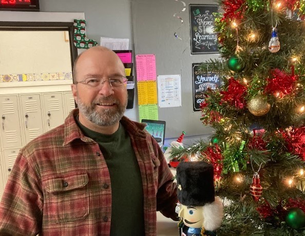 teacher smiling next to a tree