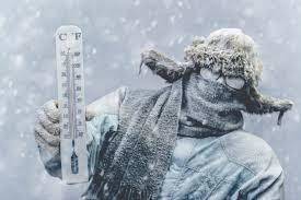 Man standing in the cold with a thermometer